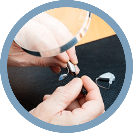 Hearing specialist repairing hearing aids in office