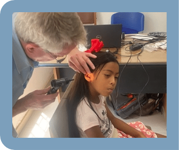Kurt Chappell, audiologist examining a young patients ears